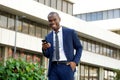 African american corporate businessman laughing with mobile phone in the city Royalty Free Stock Photo