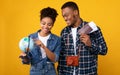 African American Couple Choosing Travel Destination Holding Globe, Yellow Background Royalty Free Stock Photo