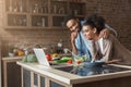 African-american couple cooking dinner with recipe on laptop Royalty Free Stock Photo