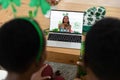 African american couple making st patrick\'s day video call with female friend on laptop at home