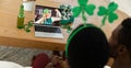 African american couple making st patrick\'s day video call with female friend on laptop at home