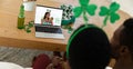 African american couple making st patrick\'s day video call with female friend on laptop at home