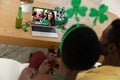 African american couple making st patrick\'s day video call with female friend on laptop at home