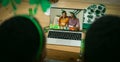 African american couple making st patrick\'s day video call with male friends on laptop at home