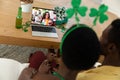 African american couple making st patrick\'s day video call to female friend on laptop at home