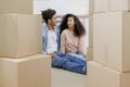 African American couple moving new home. man, woman are sitting among boxes talking mortgage Royalty Free Stock Photo