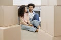 African American couple moving new home. man, woman are sitting among boxes talking mortgage Royalty Free Stock Photo