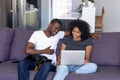 African American couple with pet relax on couch with laptop Royalty Free Stock Photo