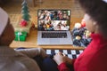 African american couple with santa hats having christmas video call with happy diverse families Royalty Free Stock Photo