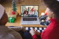 African american couple with santa hats having christmas video call with happy diverse family Royalty Free Stock Photo