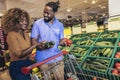 African american couple shopping for healthy fresh food at produce section of supermarket Royalty Free Stock Photo