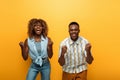 African american couple showing yes gesture on yellow colorful background