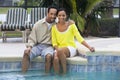 African American Couple Sitting By A Swimming Pool Royalty Free Stock Photo