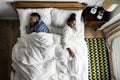 African American couple sleeping back to back