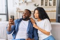 African-American couple with smartphone on the couch Royalty Free Stock Photo