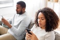 African american couple with smartphone at home