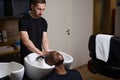 African American customer enjoys washing his hair in the barbershop