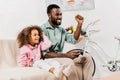 african american dad and daughter playing video game in Royalty Free Stock Photo