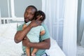 African-American dad hugs baby son holding him at home, happy family, Father`s Day