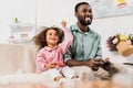 african american dad laughing with daughter and playing video game in Royalty Free Stock Photo