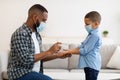 African American Dad Spraying Hand Sanitizer Disinfecting Son's Hands Indoor Royalty Free Stock Photo