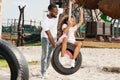 african american daughter showing two fingers on tire swing