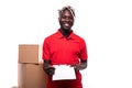 African american delivery man carrying parcel and presenting receiving form isolated on white background Royalty Free Stock Photo