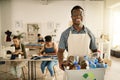 African american designer holding a recycling bin. Businessman holding a bucket of recycled plastic bottles. Young Royalty Free Stock Photo