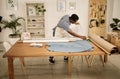 African american designer looking at fabric. Young fashion designer checking roll of material. Seamstress checking his Royalty Free Stock Photo