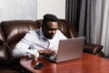 African american IT developer with laptop is programming code in office. African business man working on laptop and Royalty Free Stock Photo