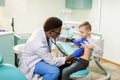 African American Doctor examining child by stethoscope. Happy child boy at the doctor`s consultation in hospital Royalty Free Stock Photo