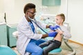 African American Doctor examining child by stethoscope. Happy child boy at the doctor`s consultation in hospital Royalty Free Stock Photo