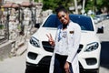 African american doctor female at lab coat with stethoscope posed outdoor against white suv car Royalty Free Stock Photo