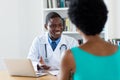 African american doctor with good news for female patient Royalty Free Stock Photo