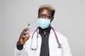 African American doctor holding syringe. attractive young doctor on gray background Royalty Free Stock Photo