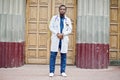 African american doctor male at lab coat with stethoscope outdoor against clinic door Royalty Free Stock Photo