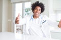 African American doctor man at the clinic looking at the camera smiling with open arms for hug Royalty Free Stock Photo