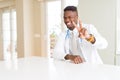 African american doctor man at the clinic smiling looking to the camera showing fingers doing victory sign Royalty Free Stock Photo