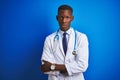 African american doctor man wearing stethoscope standing over isolated blue background skeptic and nervous, disapproving Royalty Free Stock Photo