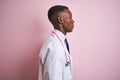 African american doctor man wearing stethoscope standing over isolated pink background looking to side, relax profile pose with Royalty Free Stock Photo