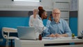 African american doctor using otoscope consulting elder man