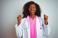 African american doctor woman wearing  pink stethoscope over isolated white background excited for success with arms raised and Royalty Free Stock Photo