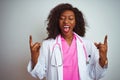 African american doctor woman wearing  pink stethoscope over isolated white background shouting with crazy expression doing rock Royalty Free Stock Photo