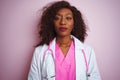 African american doctor woman wearing stethoscope over isolated pink background with serious expression on face Royalty Free Stock Photo