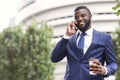 African American employee talking on mobile phone having coffee break Royalty Free Stock Photo