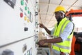 African American engineer is checking for power at main distribution board for the circuit at the factory electricity mainten Royalty Free Stock Photo