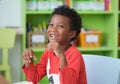 African American ethnicity kid smiling at library in kindergarten preschool classroom.happy emotion.education concept. Royalty Free Stock Photo