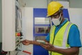 Factory worker with face mask operating with CNC machine control panel Royalty Free Stock Photo