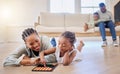African american family bonding in the lounge together at home. Black mother playing a game with her daughter while a Royalty Free Stock Photo