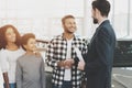 African american family at car dealership. Salesman and man shaking hands, congratulating with new car. Royalty Free Stock Photo